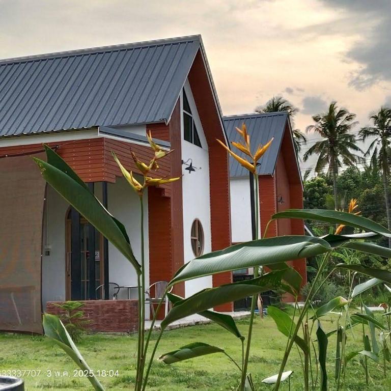 Ban Phu DinThe pool villa的一座红白色房子,前面有植物