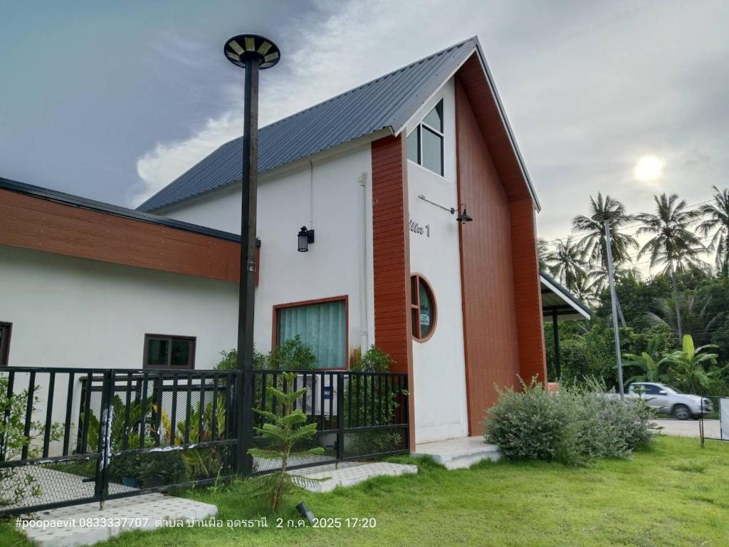 a white and orange house with a black fence at The pool villa in Ban Phu Din