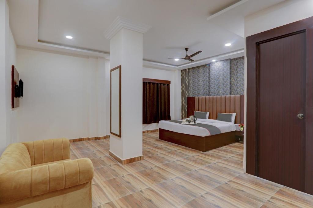 um quarto de hotel com uma cama e um sofá em FabHotel Palm Bliss em Kānpur