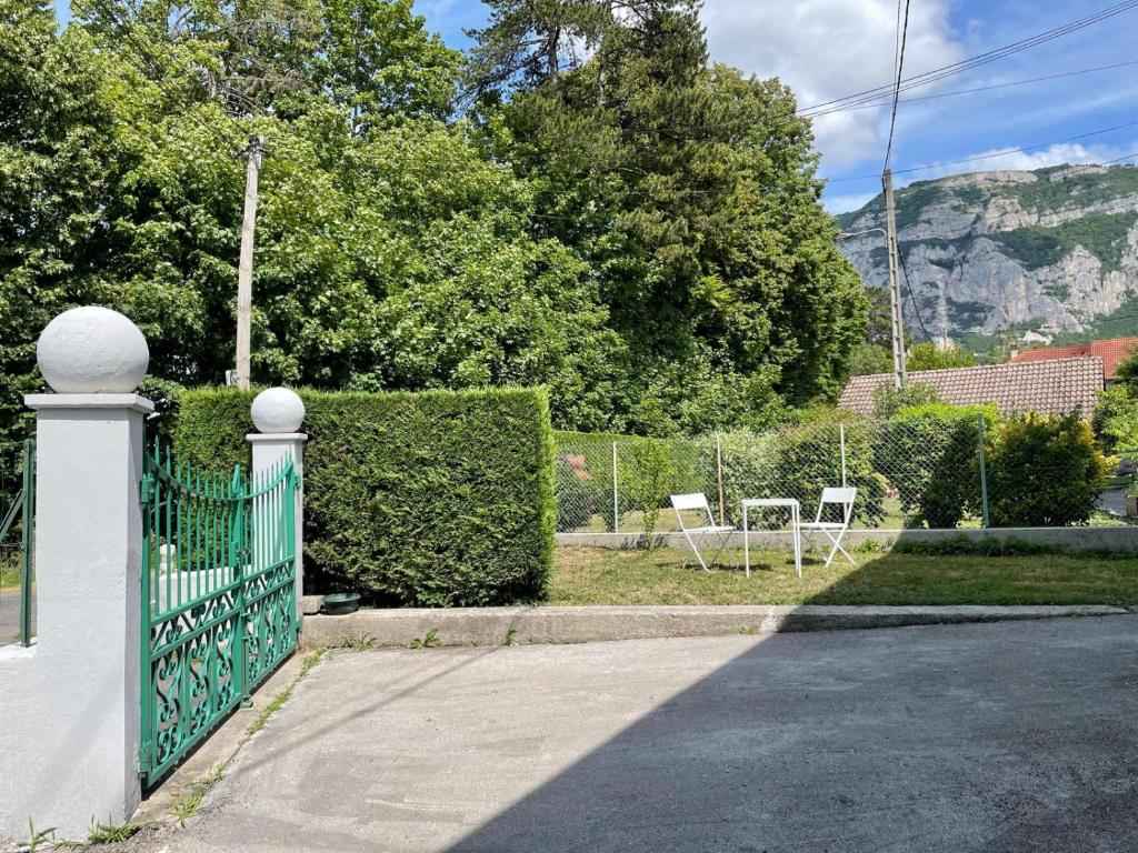 a fence with two white chairs in a yard at Appartement aux portes de Genève non PMR in Collonges-sous-Salève