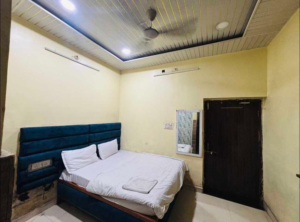 a room with a bed with a blue headboard at Hotel O Hamar Mitan in Nargora