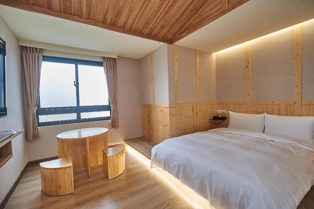a bedroom with a large bed and a window at Chillax Inn 知樂愛河館 in Kaohsiung