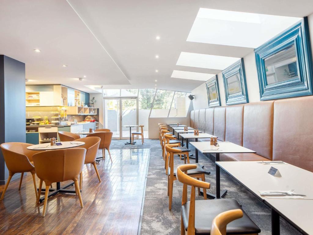 eine Reihe von Tischen und Stühlen in einem Restaurant in der Unterkunft Mantra on Northbourne in Canberra