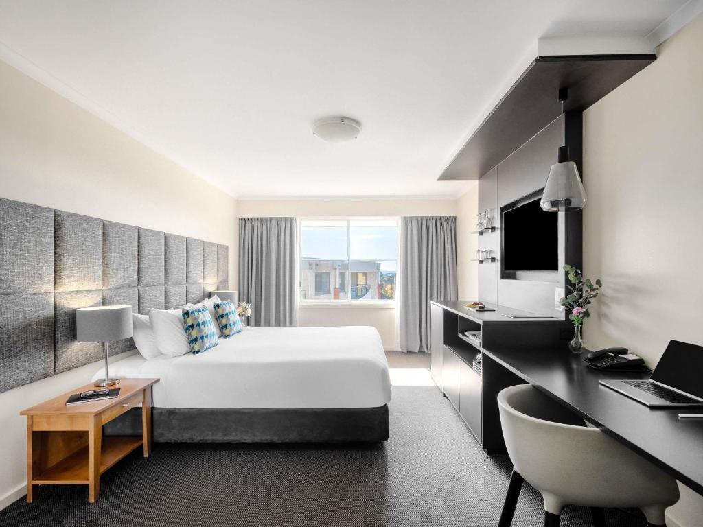 a hotel room with a bed and a desk at Mantra on Northbourne in Canberra