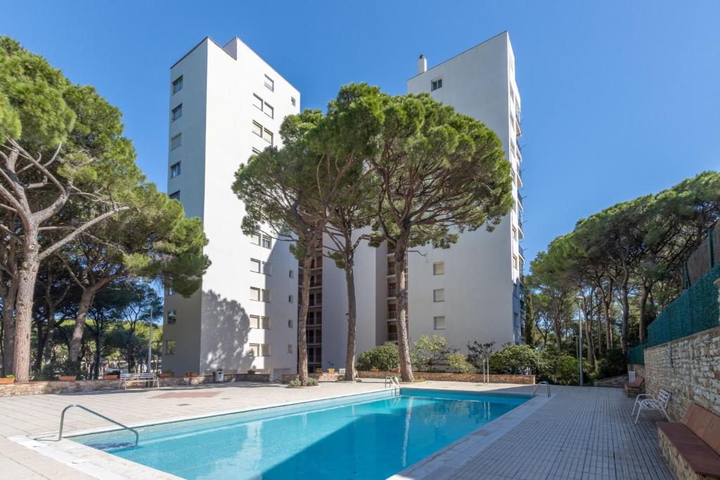 an apartment with a swimming pool and two tall buildings at Bosmar 1C in Pals