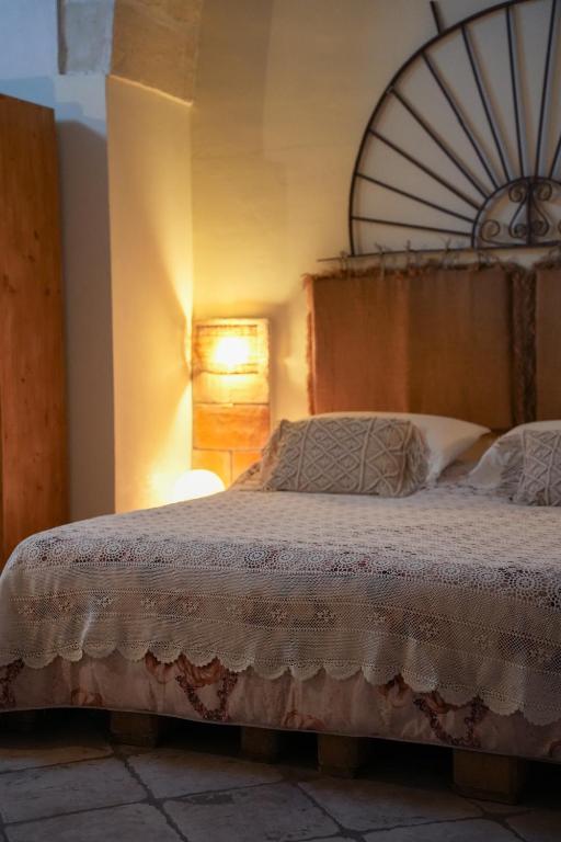 a bedroom with a large bed with a wooden headboard at Novecento Room and Breakfast Puglia in Massafra