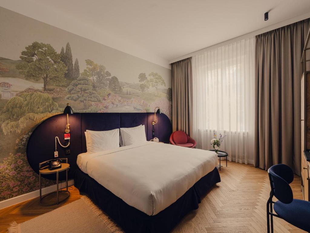 a hotel room with a bed and a painting on the wall at Flaner Hotel, WorldHotels Crafted in Warsaw