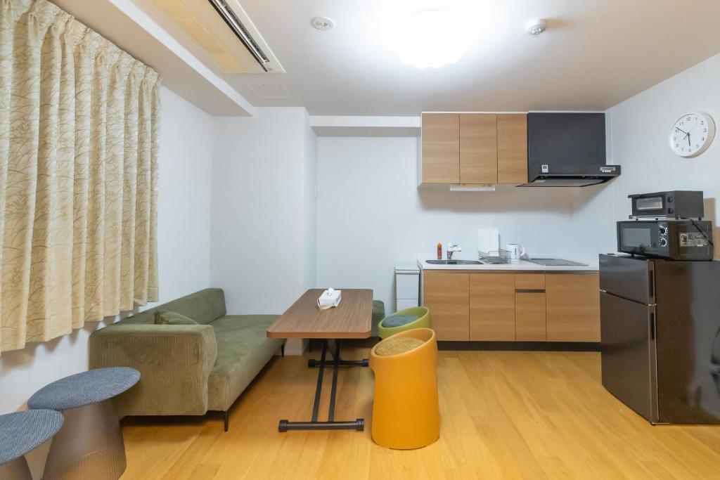 a living room with a couch and a kitchen at Shin-Imamiya Grand F in Osaka