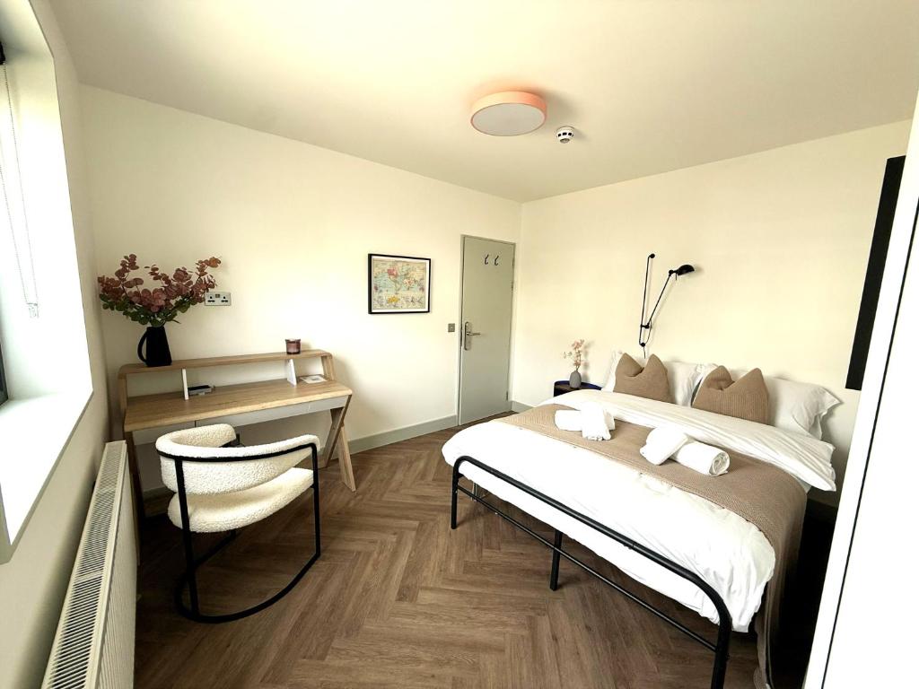 a bedroom with a bed and a desk and a chair at Crystal Palace Stylish Large Ensuite Double Room in Crystal Palace