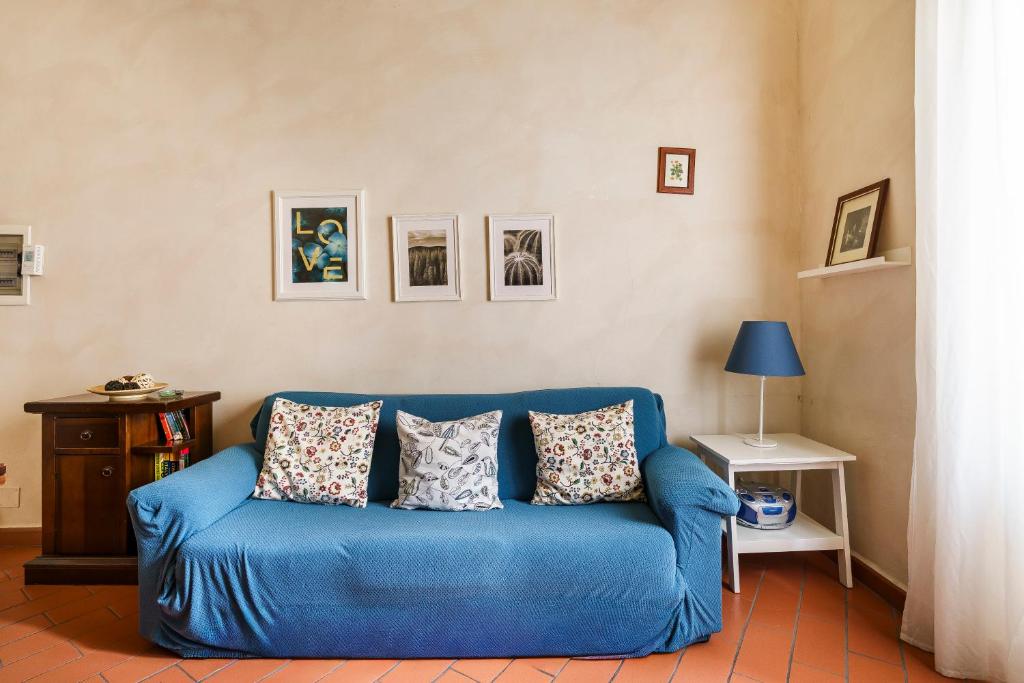 a blue couch in a living room with pictures on the wall at Inferno Double in Florence
