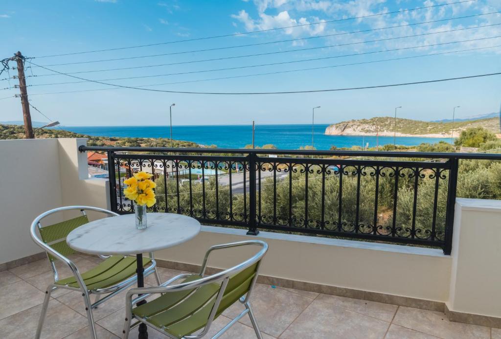 a table and chairs on a balcony with a view of the ocean at Vrokastro Apartments in Istro