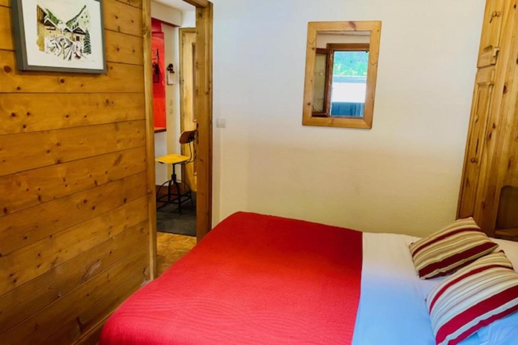 Un dormitorio con una cama con una manta roja. en Slopes Of Les Houches 25 M With Balcony, en Les Houches