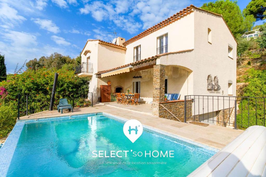 a villa with a swimming pool in front of a house at SELECT'soHOME - Magnifique villa pour 10 personnes avec piscine à débordement et vue sur la mer ! - VILLA PAVILLOU in Le Lavandou