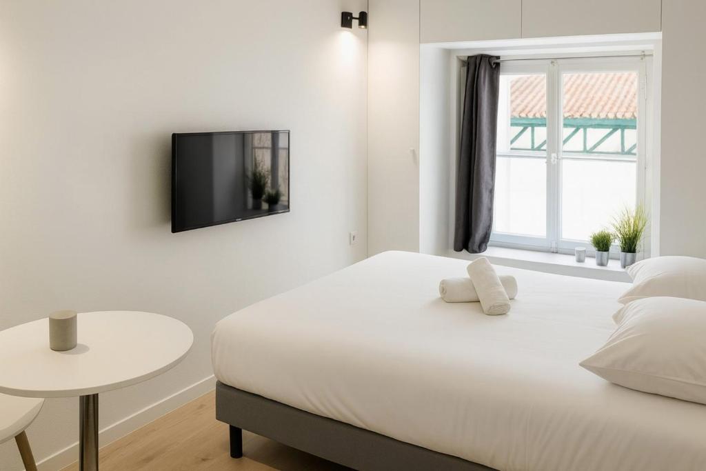 a white bedroom with a bed and a table at Ideally located studio Foch & Parc de la Tête d’Or in Gare des Brotteaux