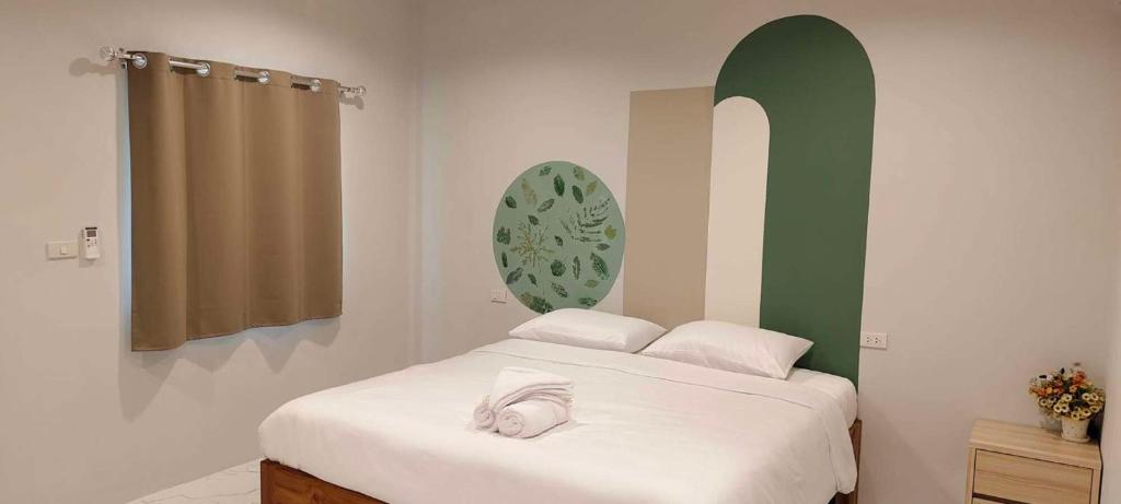 a bedroom with a bed and a green and white wall at Chiang Khan Dwelling in Chiang Khan