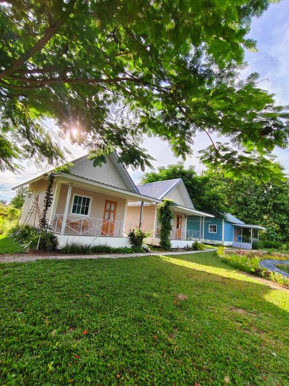a white and blue house with a yard at Chiang Khan Dwelling in Chiang Khan