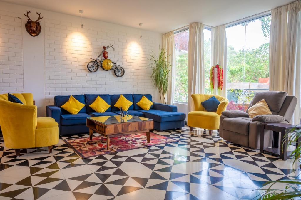 una sala de estar con sofás azules y sillas amarillas. en Casa Magnolia by Da Alohas, en Nerul