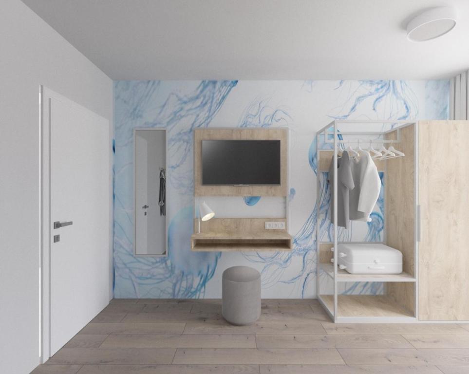 een badkamer met een tv aan een blauwe muur bij Fairschlafen Boutique Hostel Zimmer 0-16 mit Terrasse in Neustadt in Holstein