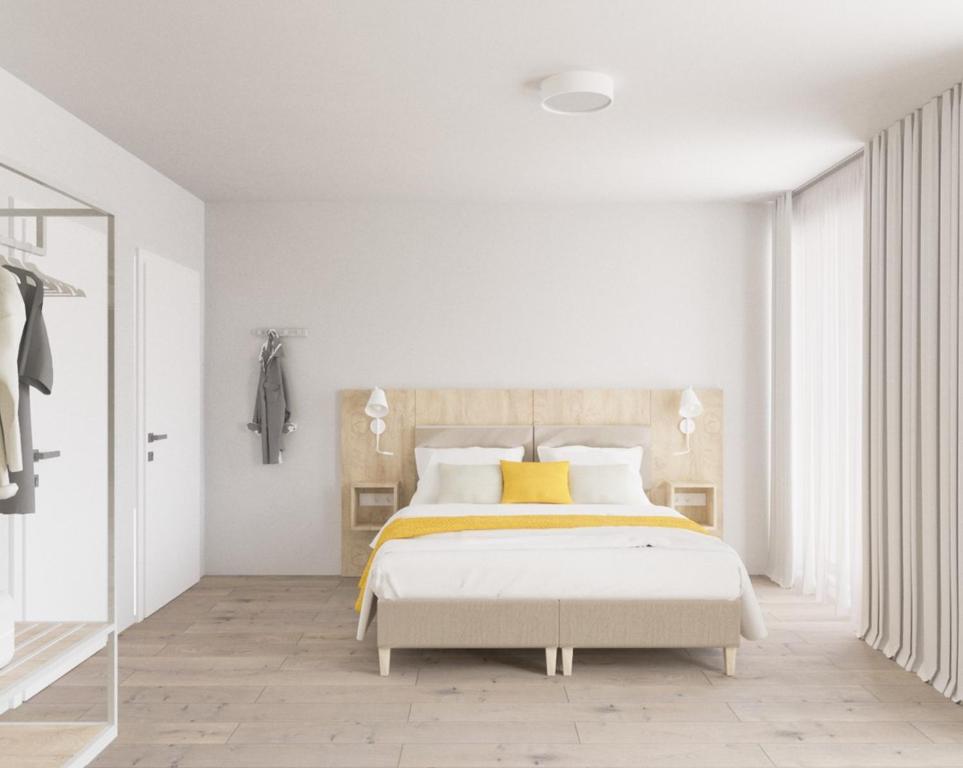 a white bedroom with a bed with a yellow pillow at Fairschlafen Boutique Hostel Zimmer 0-17 mit Terrasse in Roge