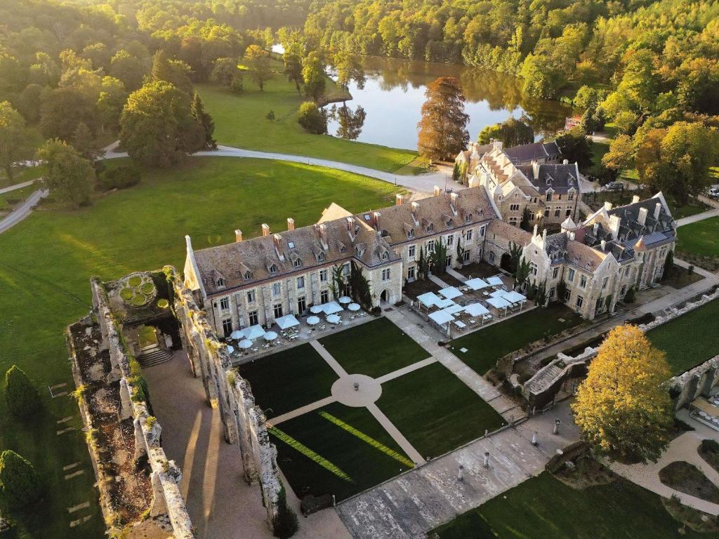 an aerial view of a mansion with a large yard at Abbaye Des Vaux De Cernay in Cernay-la-Ville