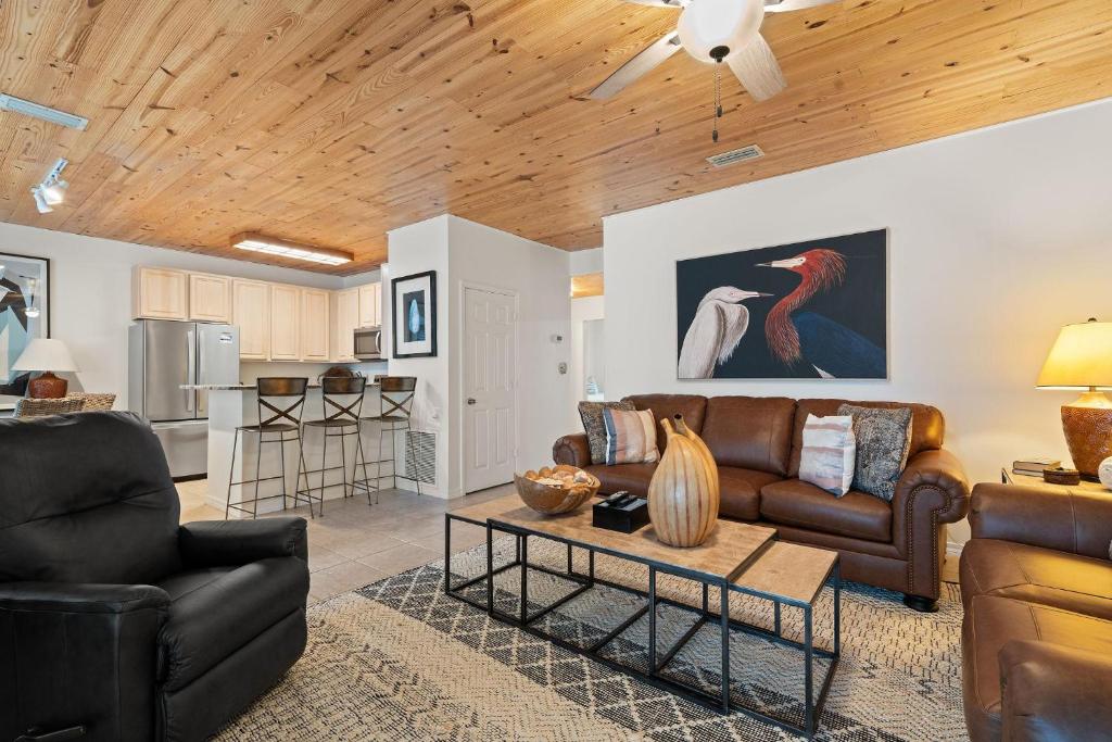 a living room with leather furniture and a kitchen at Charter Landing A7 in Orange Beach