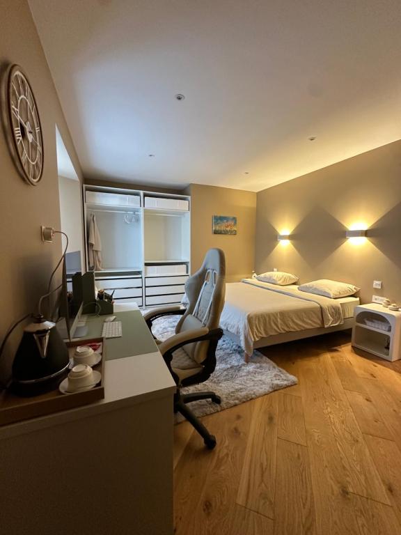 a bedroom with a bed and a desk with a chair at Charmant manoir rénové avec chambres indépendantes et salles de bain privatives, in Domagné