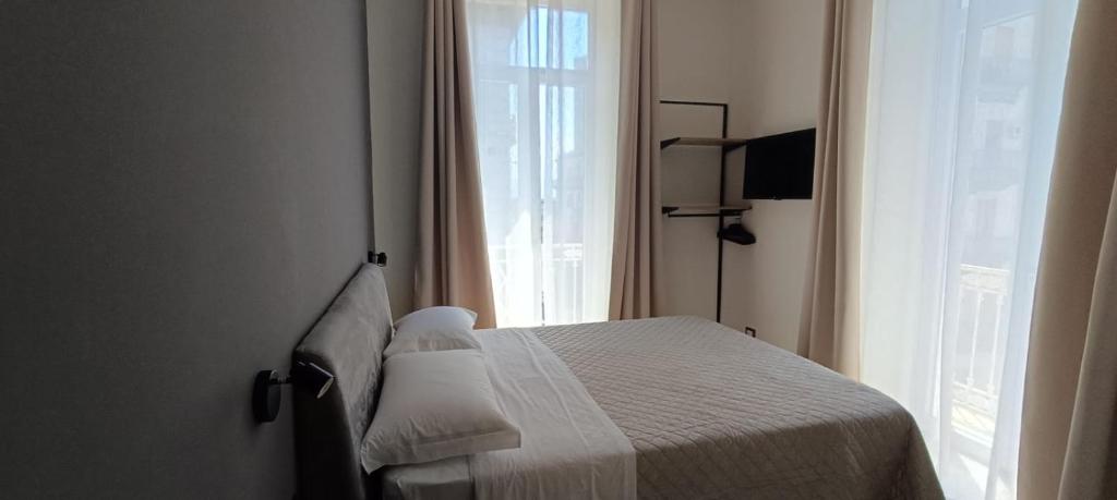 a bedroom with a white bed with a window at Misciù in Naples