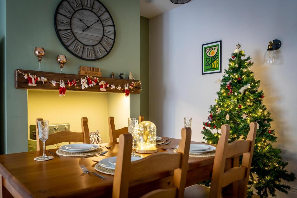 a dining room table with a christmas tree and a clock at Shorethwaite in Amble