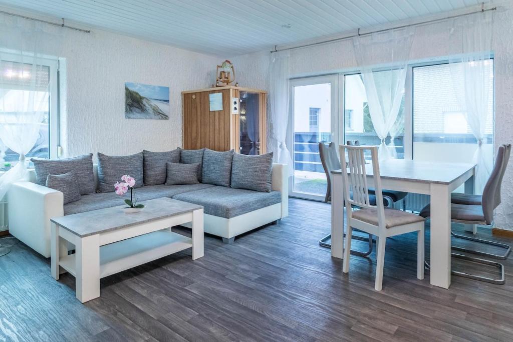 ein Wohnzimmer mit Sofa und Tisch in der Unterkunft CBlue "Kaptain Carl", Terrasse, Grill, Strandnah in Graal-Müritz