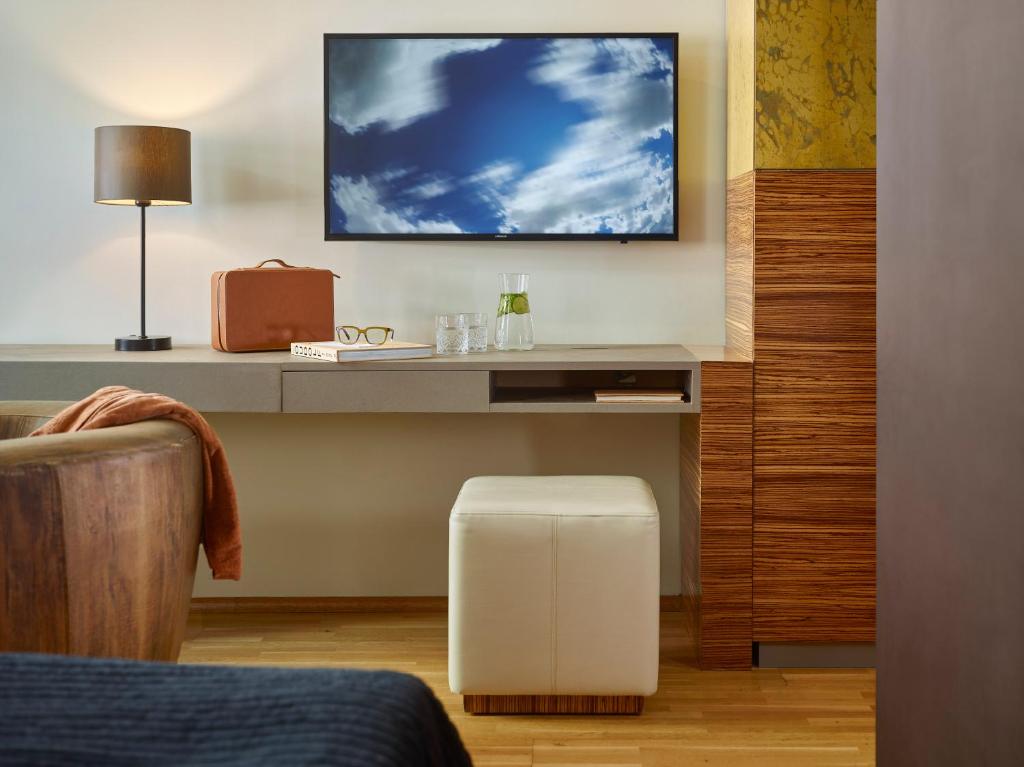 a room with a desk with a tv and a stool at The ICON Prague in Prague