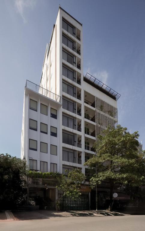 a tall white building with a lot of windows at WH Bassac Residence in Phnom Penh