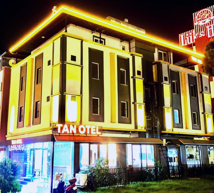 a large yellow building with a sign on it at TAN OTEL in Mersin