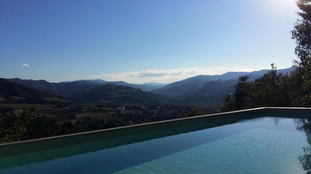 a swimming pool with a view of mountains at Nido D'Ape bed and breakfast in  Montepetra 