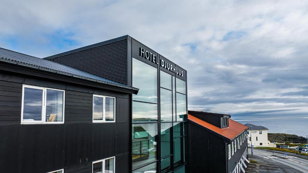 a black building with a sign on the side of it at Hotel Djurhuus in Tórshavn