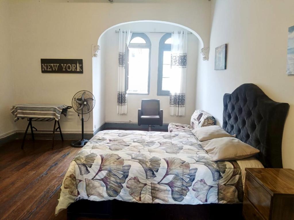a bedroom with a bed and a desk and a window at Casa Turística Monumental in Lima