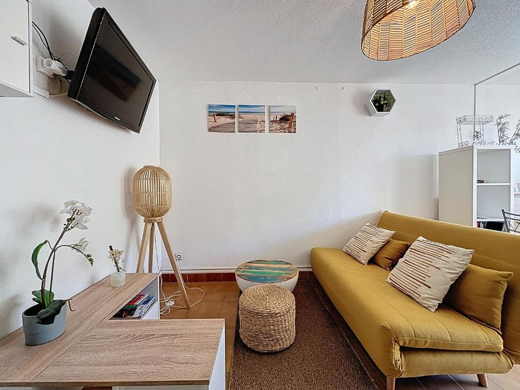 ein Wohnzimmer mit Sofa und Tisch in der Unterkunft Le Muge - Appartement Rez-de-chaussée - Piscine in Narbonne-Plage