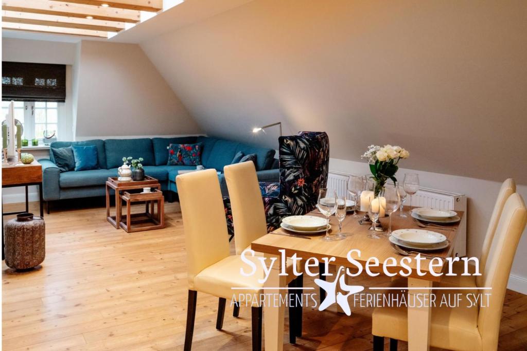 a living room with a table and a blue couch at Sylter Seestern App Lavendel in Morsum