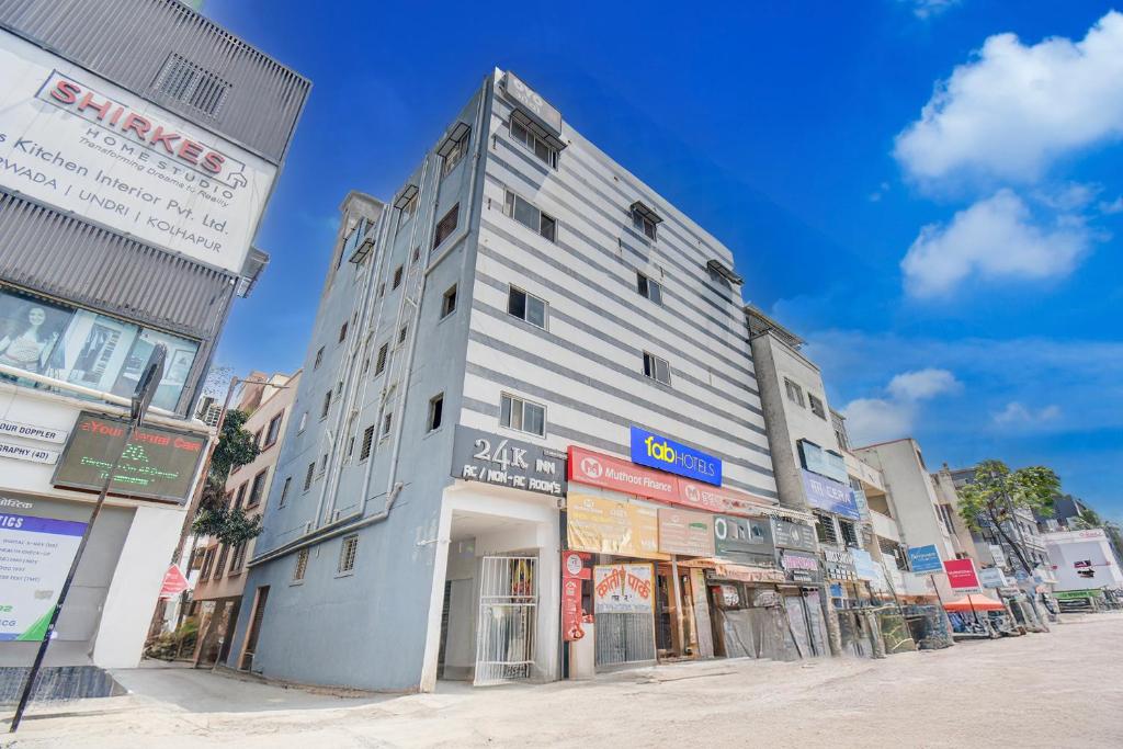 a tall white building on the side of a street at Via 24K Inn - Nr Manipal Hospital in Mundhwa