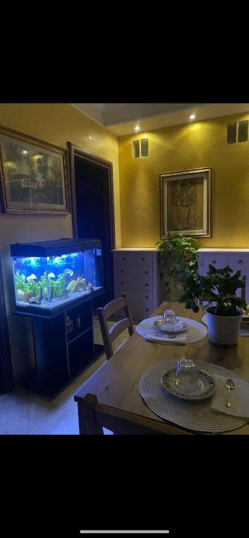 a living room with a table and a fish tank at B&B Le Camelie in Nettuno
