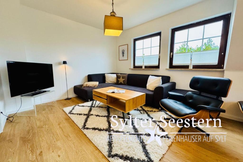 a living room with a couch and a tv at App Blaue Welle in Morsum