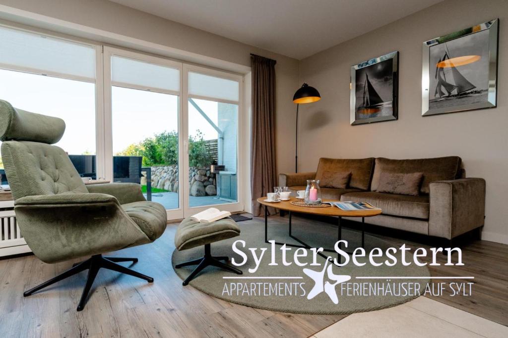 una sala de estar con una silla y un sofá en Sylter Seestern Haus Nösseblick, en Morsum