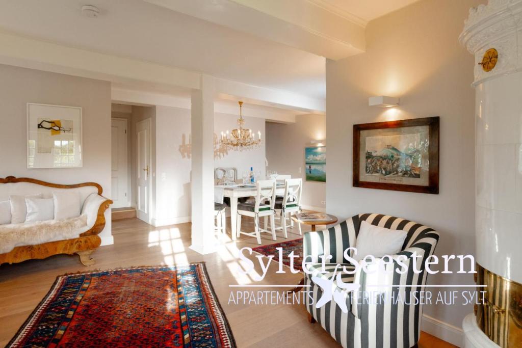 a living room with a table and chairs and a dining room at Sylter Seestern Haus Deichblick in Morsum