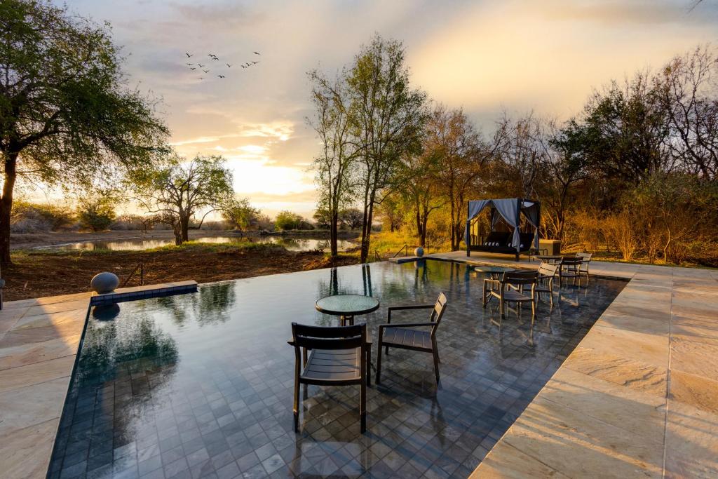 a patio with a table and chairs and a pool at Black Rhino Game Lodge in Pilanesberg