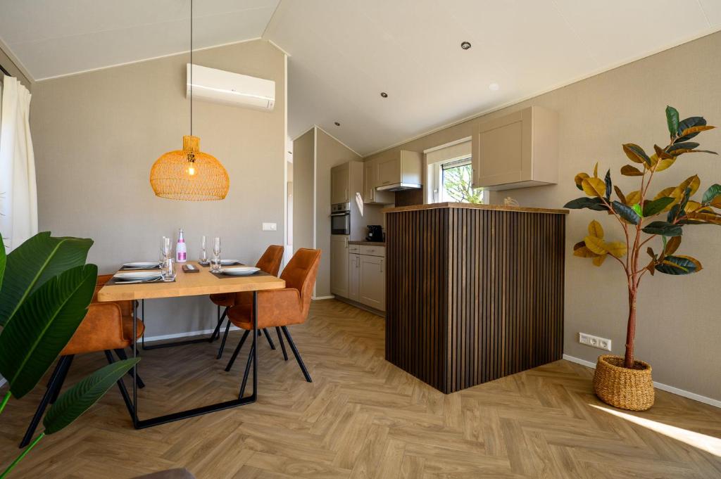a kitchen and dining room with a table and chairs at Chalet Charleston 069 im Heide Resort in Brüggen