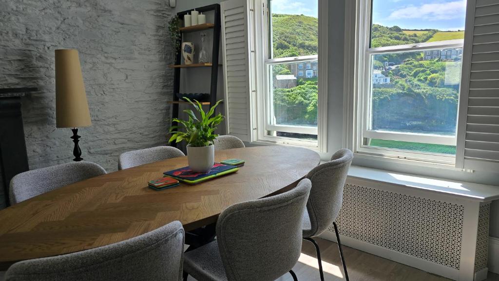 a table and chairs in a room with windows at Headmasters House in Port Isaac