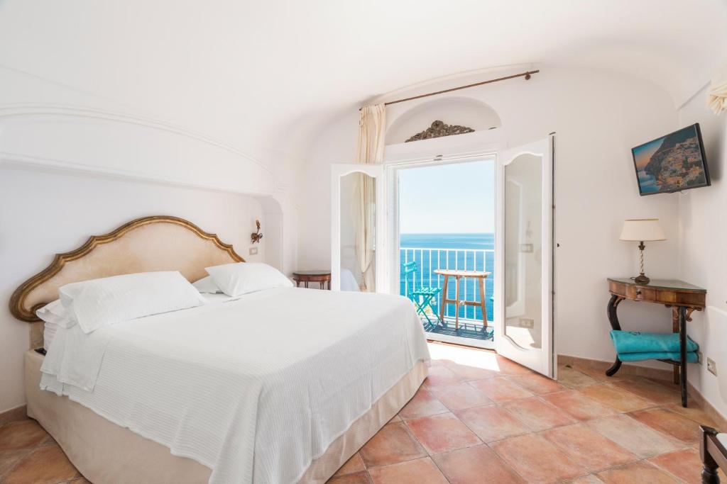 a bedroom with a bed and a view of the ocean at Calante Luna in Praiano
