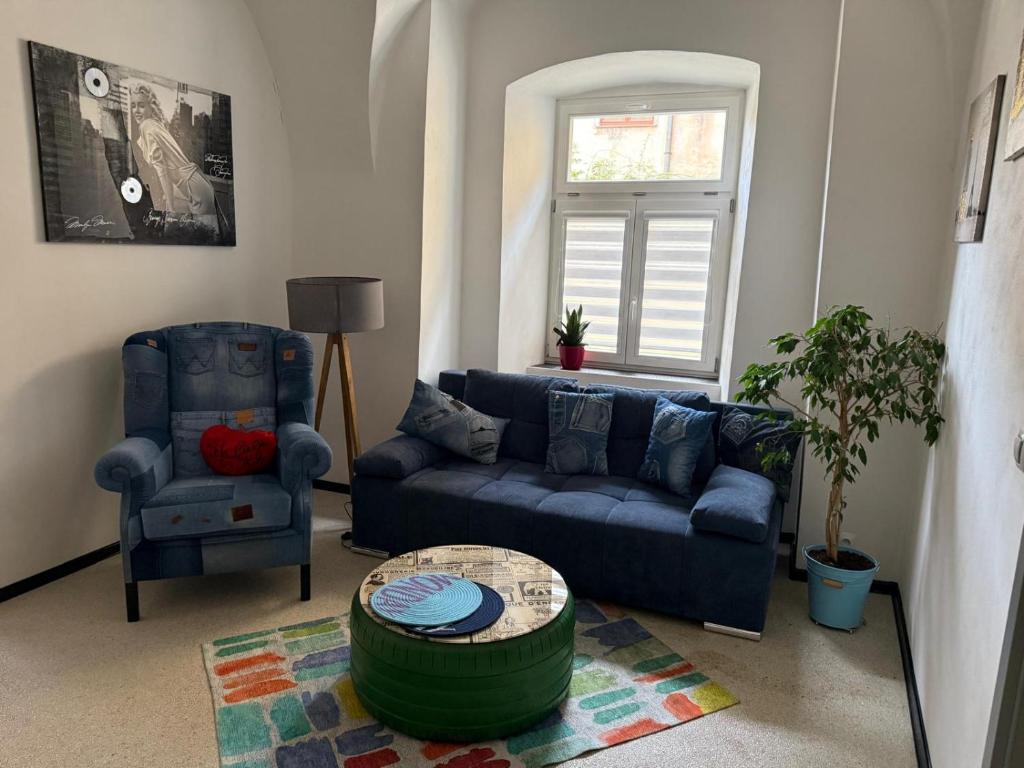 a living room with a blue couch and a chair at Apartman I Ubytovani v centru Jihlavy in Jihlava