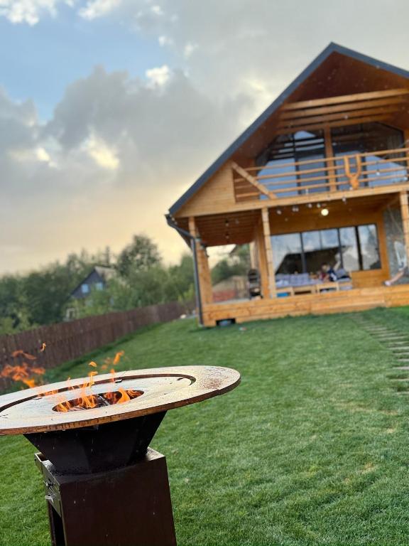 a fire pit in front of a house at Cabana de sub mesteceni in Mătişeşti