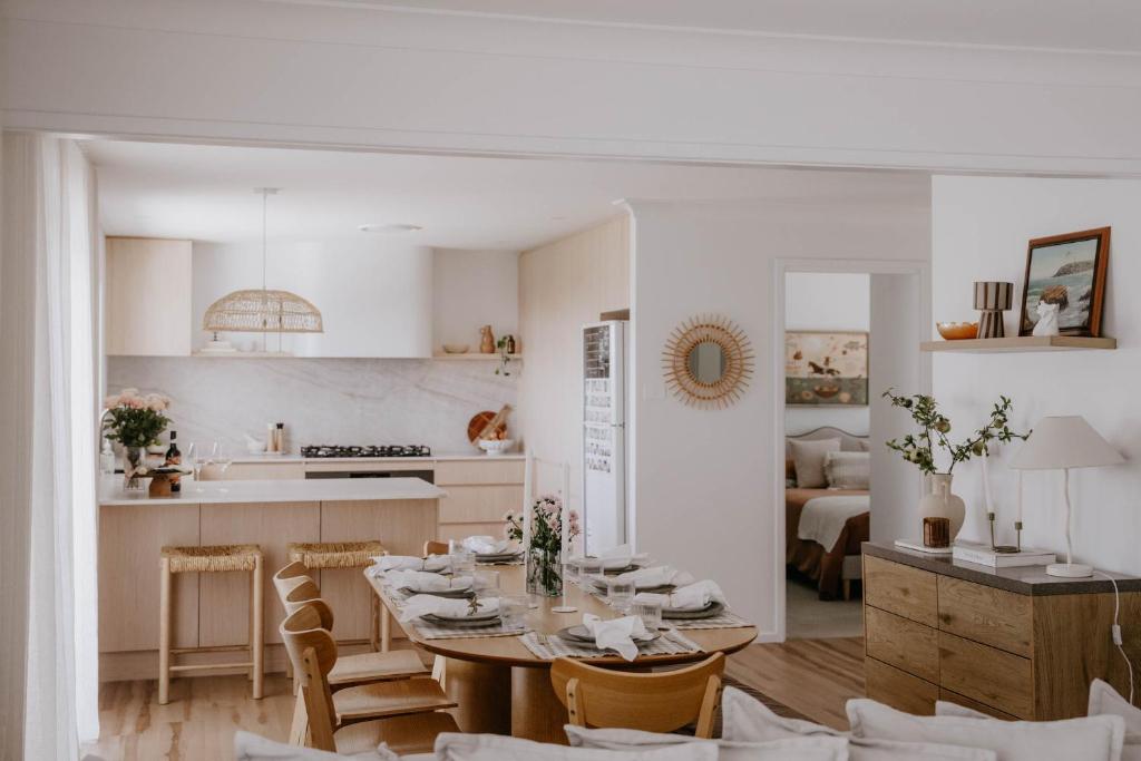 een keuken en een eetkamer met een tafel en stoelen bij Phoenix Jervis Bay Family Coastal Escape in Vincentia