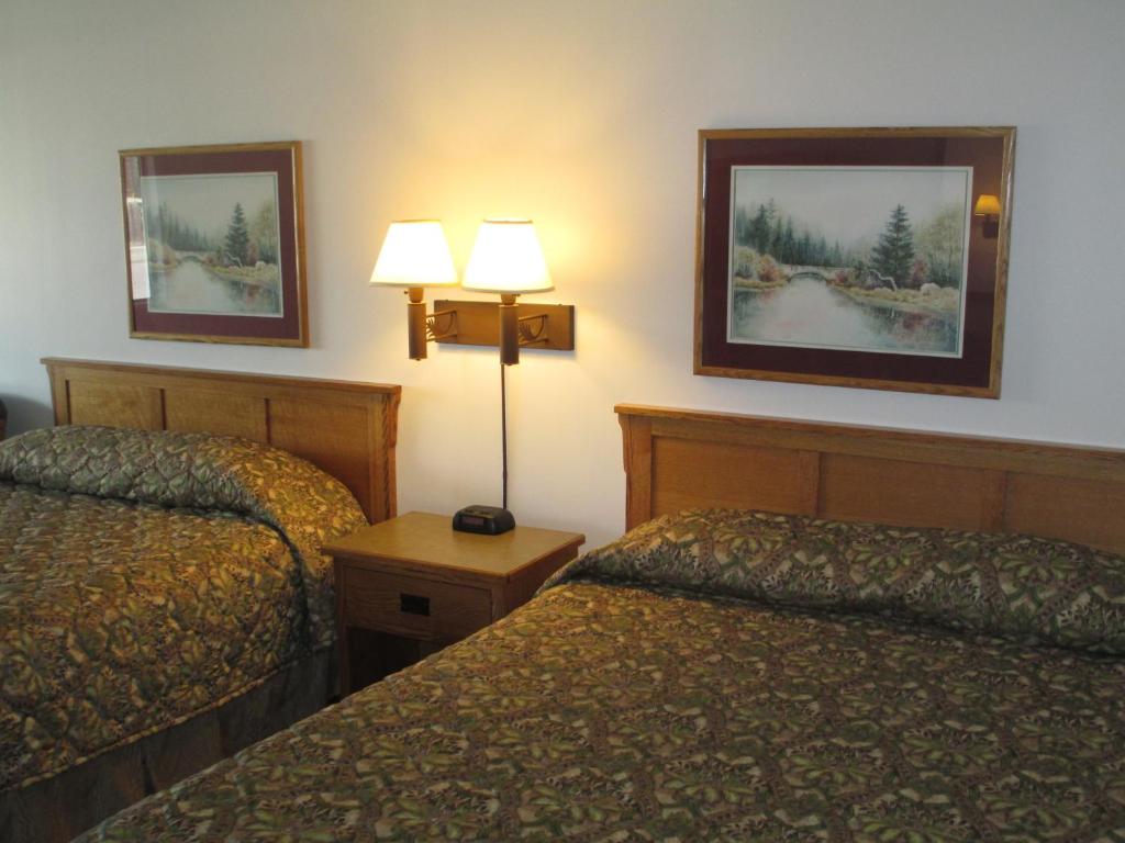 a hotel room with two beds and two lamps at Bozeman Inn in Bozeman